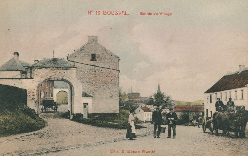 La ferme Saint Martin et l'entrée du village de Bousval au temps où il n'y avait pas encore d'électricité. Des habitants parlent ou conduisent une charette tirée par des chevaux de trait